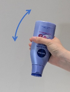 キャップを閉めたまま容器の口元を下にしてボトルを振っている写真